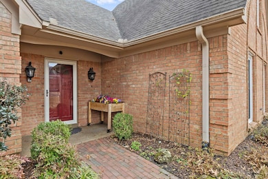 Entrance to property featuring a shingled roof and