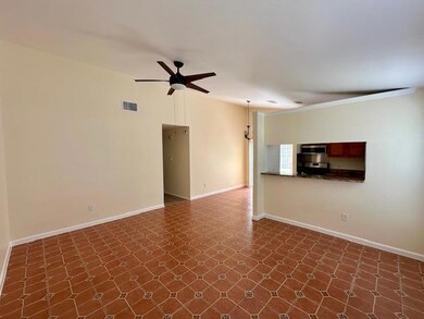 Empty room featuring a ceiling fan and dark floors