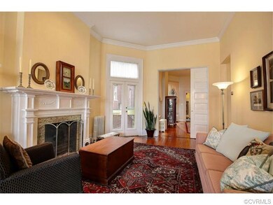 This is a view of the other side of the living room with an additional gas fireplace, french doors to a new deck extending to the side yard and pocket doors opening to the dining room. On the right side is a doorway to the front foyer which provides 