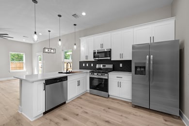 Modern kitchen with sleek white cabinetry, stainle