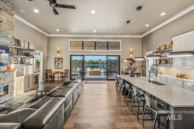 Living area featuring ceiling fan, crown molding, wood-type flooring, a fireplace, and recessed lighting