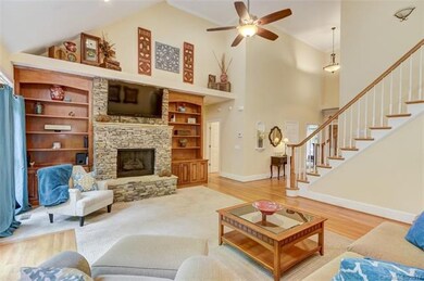 Great Room boasts a soaring ceiling, custom shelvi