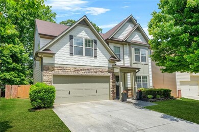 Craftsman house with driveway, stone siding, and a