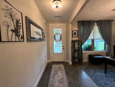 Tiled foyer featuring healthy amount of natural light and baseboards