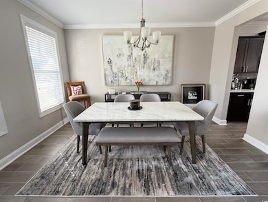 Dining space featuring a chandelier, wood finish floors, and crown molding