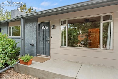 View of exterior entry with a chimney and brick siding