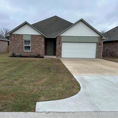 Ranch-style house featuring a garage and a front y