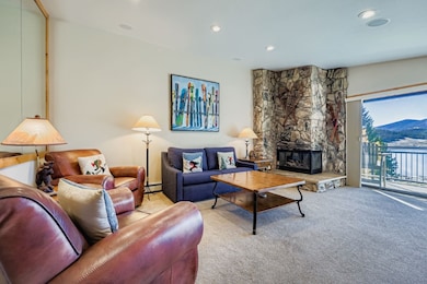 Carpeted living area with a fireplace, recessed lighting, and a baseboard heating unit