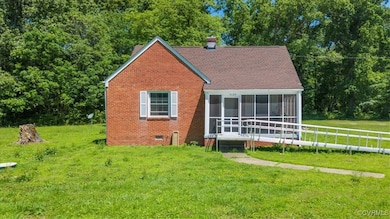 View of front of home featuring a sunroom, a chimn