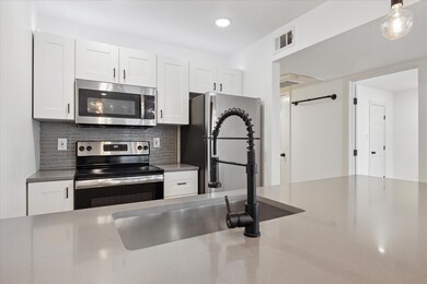 Kitchen with stainless steel appliances, white ca