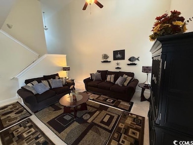 Carpeted living room featuring ceiling fan
