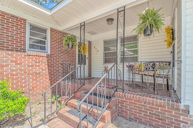 Property entrance featuring a porch and brick sidi