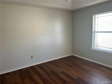 Empty room featuring plenty of natural light, baseboards, and dark wood finished floors