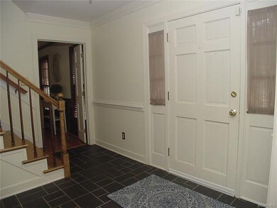 Spacious foyer has slate floor, crown molding & ch