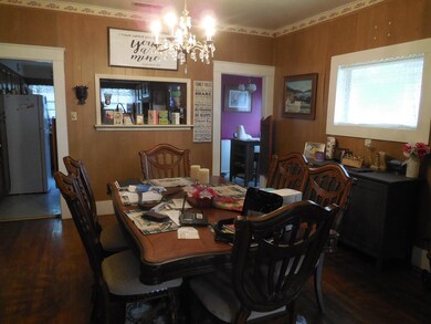 Dining area with dark wood-type flooring and a cha