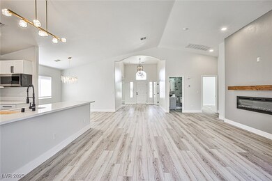 Unfurnished living room with lofted ceiling, arche