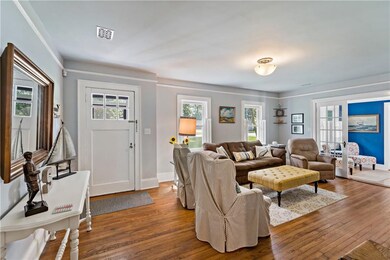 Spacious living room with hardwood flooring, frenc