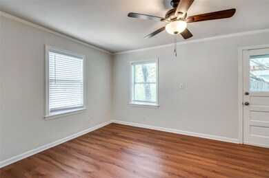 Empty room with crown molding, wood-type flooring,
