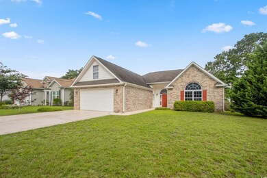 View of front of home with driveway, a front lawn, brick siding, a garage, and a shingled roof