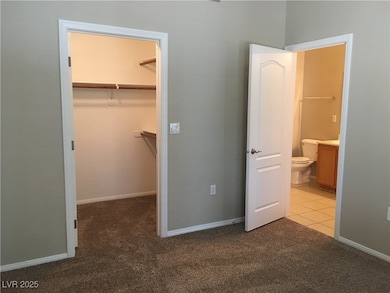 Unfurnished bedroom with a walk in closet, carpet,