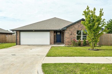 View of front of property featuring a garage, driveway, brick siding, and roof with shingles