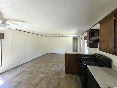 Kitchen featuring ceiling fan, black appliances, light countertops, a textured ceiling, and dark brown cabinets