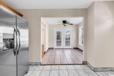 Tiled foyer with ceiling fan and french doors