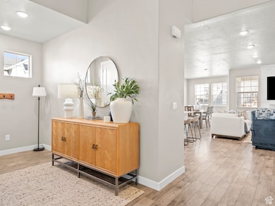 Hallway with light wood-type flooring and recessed lighting