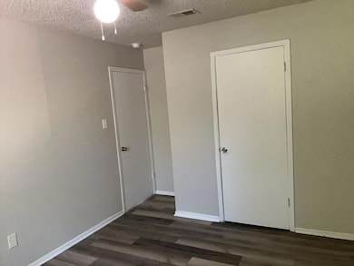Unfurnished bedroom with a textured ceiling, dark
