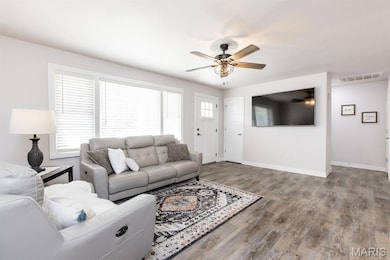 Living area with wood finished floors and a ceiling fan