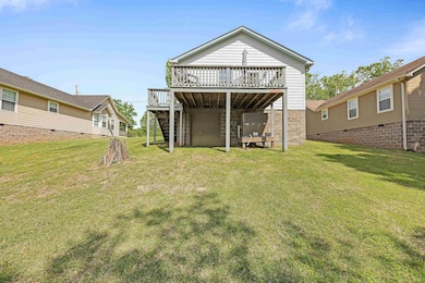 Rear view of house with a wooden deck, a yard, stairway, and crawl space