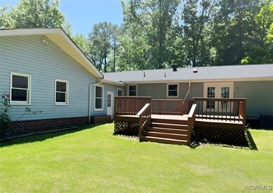 Rear view of property with a wooden deck, a lawn,