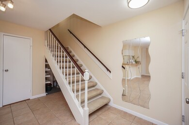 This entryway features a carpeted staircase with w