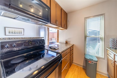 Kitchen featuring baseboards, light stone counters