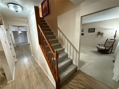 Stairway with wood finished floors and baseboards