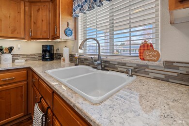Kitchen featuring brown cabinets, backsplash, and light stone counters