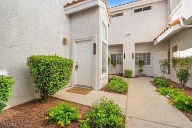 Property entrance with a tile roof and stucco sidi