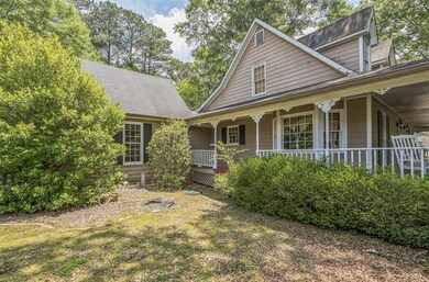 View of front of home with a porch, a shingled roof, and a front lawn