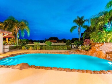 Resort backyard features heated pool with waterfal