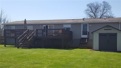 The rear of this home features the deck, shed and 