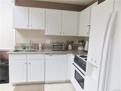 The kitchen is bright with white cabinets and two skylights!