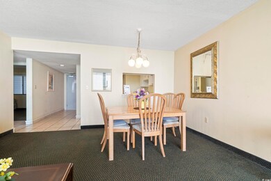 Dining room with a chandelier, light carpet, baseb