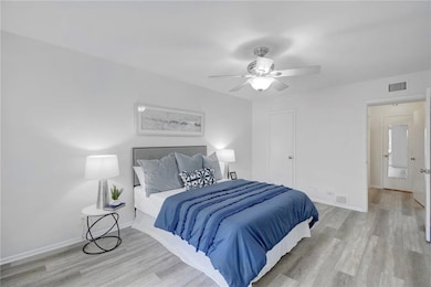 Bedroom featuring baseboards, a ceiling fan, wood