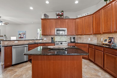 Experience culinary charm in this well-appointed kitchen. It offers abundant storage with attractive wood cabinetry, durable granite countertops, and a functional island with breakfast bar, all designed for comfort and convenience