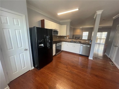 Kitchen with a sink, dark countertops, dark wood-s