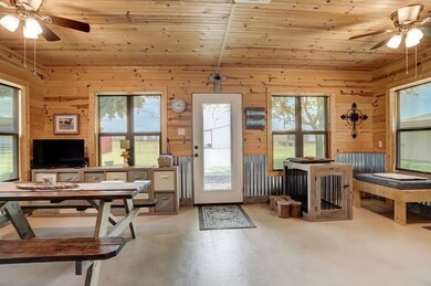 This sunroom features rustic wooden walls and ceil