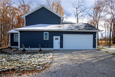 View of home's exterior featuring gravel driveway and an attached garage