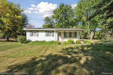 Ranch-style home with a porch, a chimney, and a front lawn