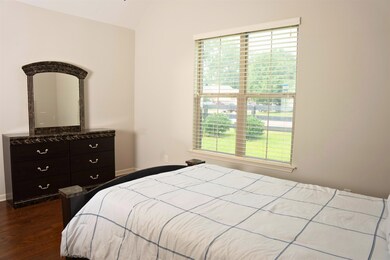 Bedroom with dark hardwood / wood-style flooring