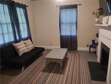 Living area featuring baseboards and a fireplace with flush hearth